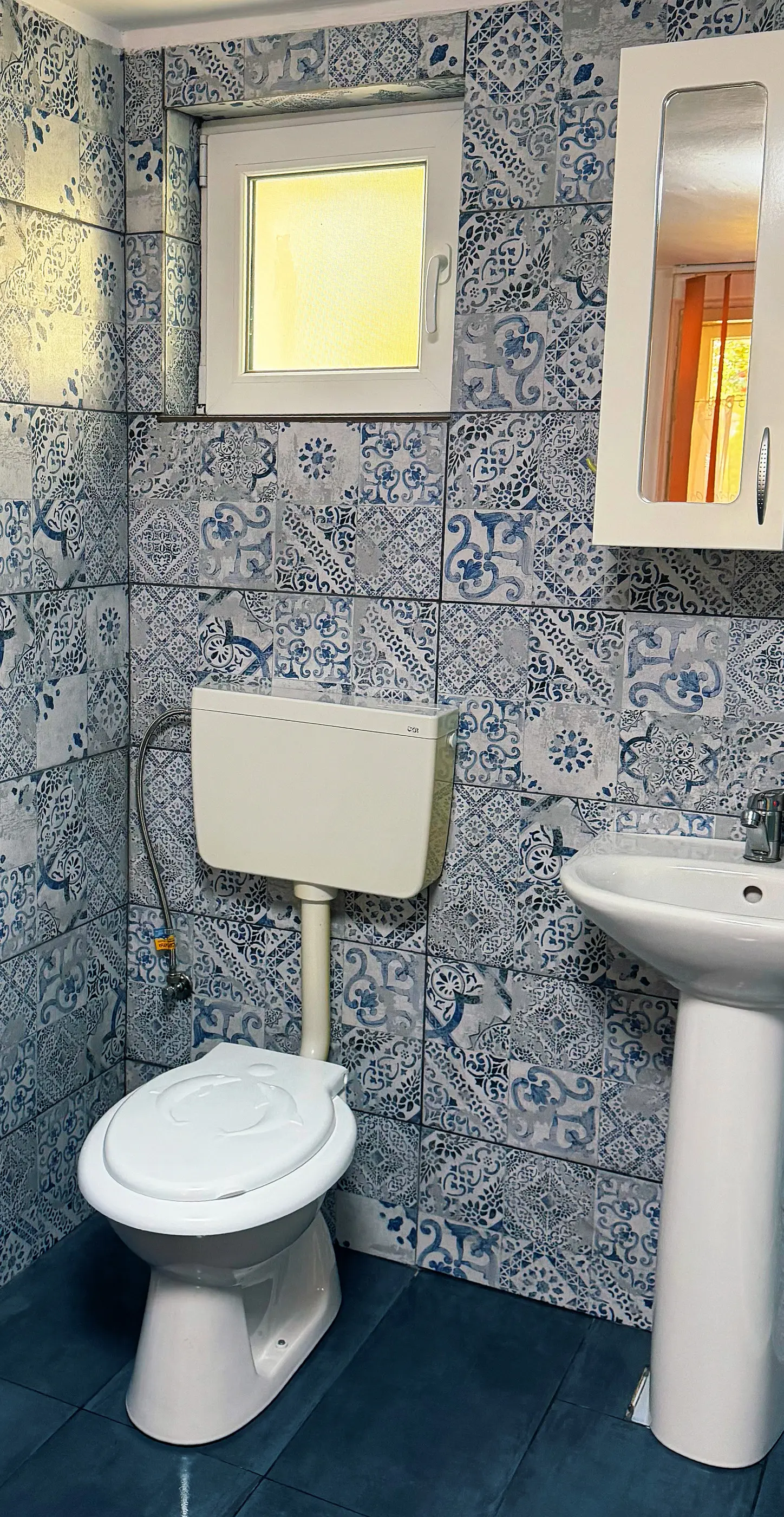 Baia cu faianță albastră cu motive și fereastră