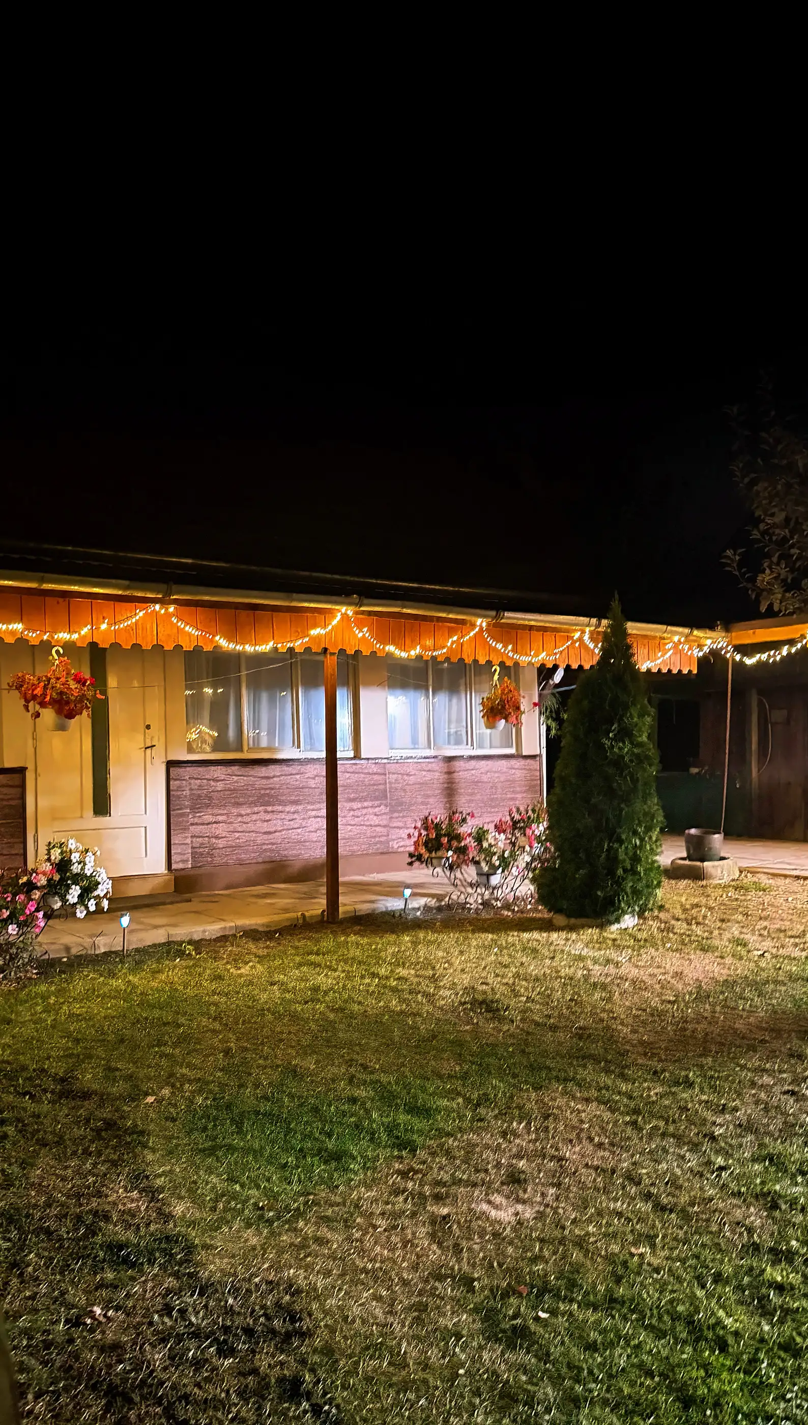 Casa Steluța seara, cu instalația luminoasă aprinsă sub streașină