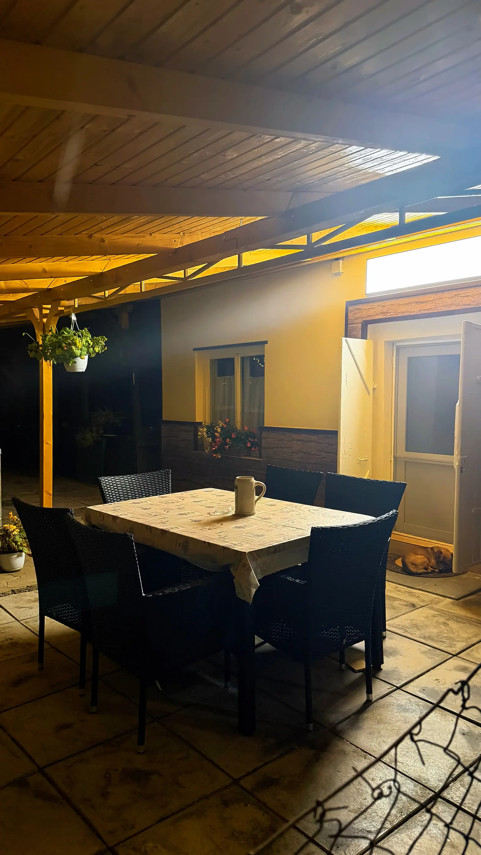 Terasa luminată cald seara, în curtea casei
